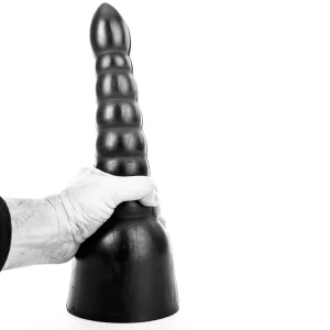 A hand grips the base of the All Black Waldemar Dildo AB17, a large black ribbed anal dildo, standing upright against a white background.