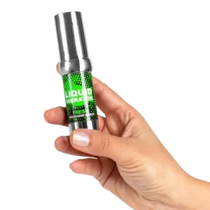A hand holds a small green and silver bottle labeled "Secret Play Liquid Vibrator Stimulator Fresh" against a white background.
