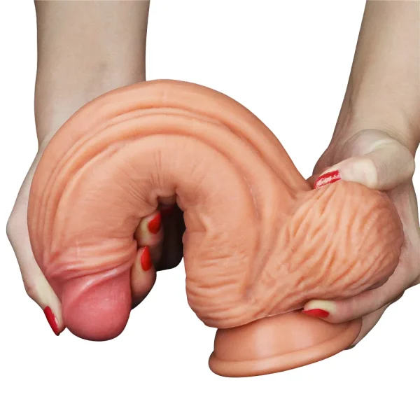 A person holding The Muscle 10 Inch Dual Layered Silicone Suction Cup Cock Dildo and bending it to show its flexibility.
