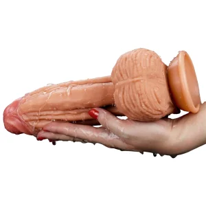 A hand holding The Muscle 10 Inch Dual Layered Silicone Suction Cup Cock Dildo covered in water showing the toy is waterproof.
