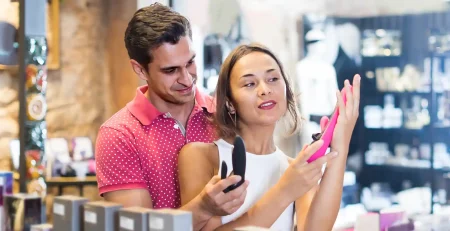 couple choosing sex toy in a sex shop