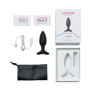 The image displays the contents of the Lovense Hush 2 Small App Controlled Rechargeable Vibrating Butt Plug package: the black plug, charger, user manual, quick setup guide, black storage pouch, and product box with a device illustration.