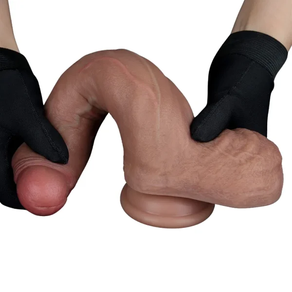A pair of gloved hands bends the Nature Cock 8.5 Inch Realistic Dual Layered Silicone Dildo, a lifelike flesh-coloured penis model, against a white background.