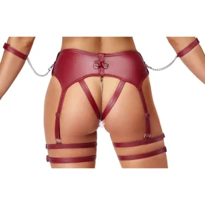 Close up of the bottom of a person wearing the Cottelli Bondage Wireless Bra & Crotchless Suspender Thong Set, a red leather harness with straps and chains around the waist, thighs, and arms, featuring an open back and a decorative jewel detail.