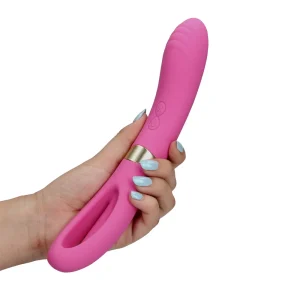 A hand with light blue nail polish holds the Loveline Double-Sided Flapping and G-Spot Vibrator, shown in pink with a curved handle and control buttons on the shaft, against a white background.