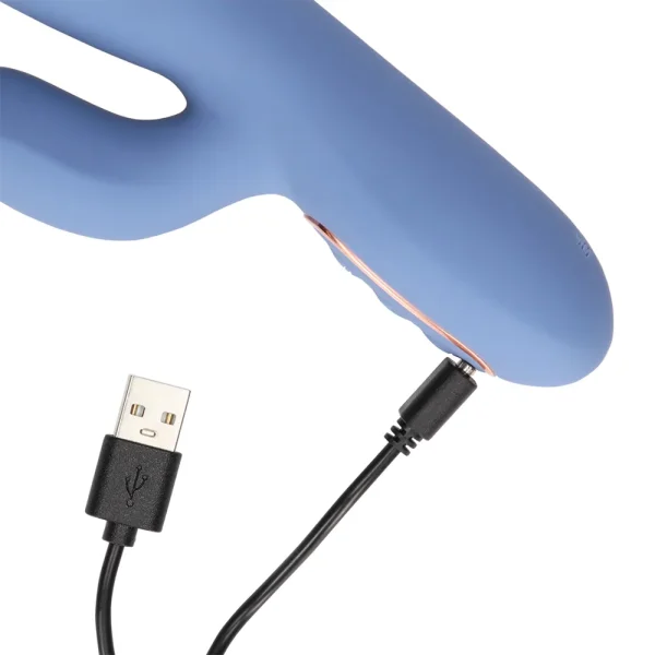 The Loveline Warming Rotating Beads and Thrusting Rabbit Vibrator in blue silicone is being connected to a black USB charging cable via its charging port.
