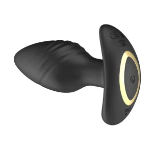 The Toosh Remote Controlled Silicone Rotating and Vibrating Butt Plug features a black textured silicone shaft, wide flared base with a gold accent ring, and an easy-access power button on the base of the toy.