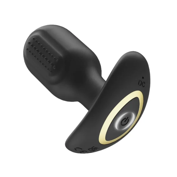 A black Toosh Remote Controlled Silicone Vibrating Butt Plug with flat oval base, circular power button, and gold accent, the power is on.
