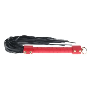 The Ouch Milan Collection Flogger is a black bonded leather flogger with multiple tails, a red handle, gold-coloured rivets, and a metal ring at the end.