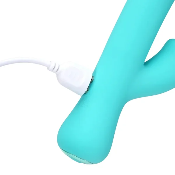 The Maia Toys Zara Rechargeable 10 Function Rabbit Vibrator in turquoise is being charged with a white USB cable connected to its metal charging ports.