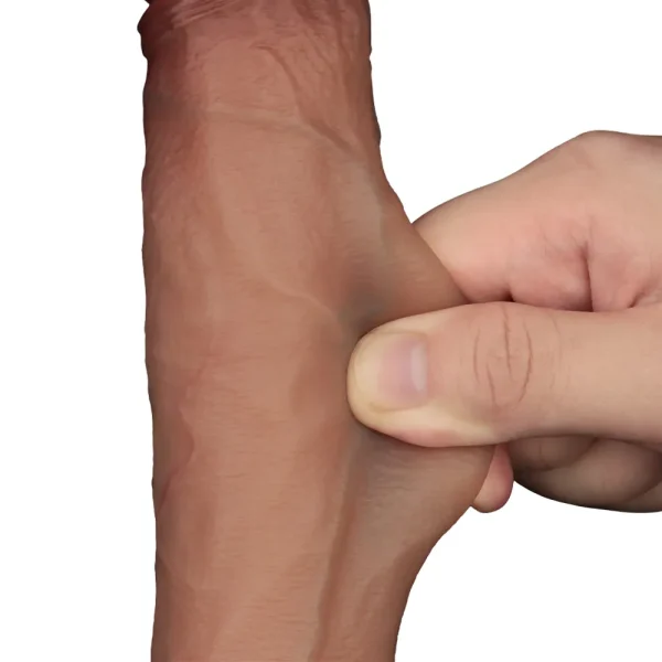 A close-up of a hand pinching and pulling the skin on the Sliding Skin Pro Realistic 9 Inch Dual Layer Silicone Dildo, demonstrating its lifelike elasticity against a white background.