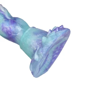 A close-up of the Tyrannosaurus 10 Inch Fantasy Dinosaur Dildo base, a blue and purple silicone toy with a textured design featuring ridges, scales, and a flared base.