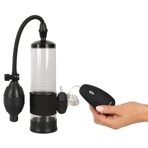 A hand holds a black remote control next to the Rebel 7-Piece Performance Sex Toy Sets penis pump.