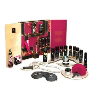 The Shunga Calendar of Desires is a luxurious gift set featuring sensual items like sprays, oils, a feather tickler, an blindfold, a pearl necklace, a vibrator, and more, beautifully displayed on a white background.
