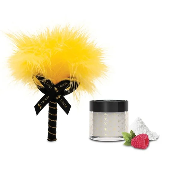 The Shunga Calendar of Desires features a yellow feather tickler with a black handle and ribbon beside a small jar of white powder, accented by a raspberry and mint leaf.