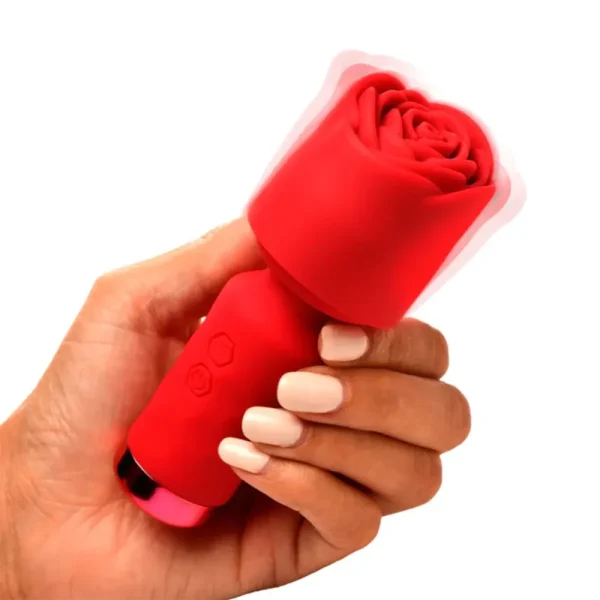 A hand with manicured nails holds the Bloomgasm Pleasure Rose Petite Mini Silicone Rose Wand, a red rose-shaped silicone vibrator with vibration lines around the flower, set against a plain white background.