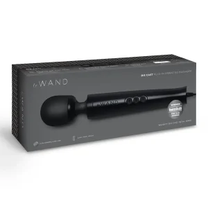 A boxed Le Wand Diecast Plug In Vibrating Wand Massager in black, featuring product images, details, and a "Winner: Women's Health" award badge on the packaging.