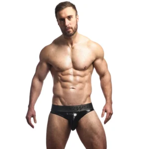 A muscular man with a beard stands against a white background, wearing only the Sukrew Fetish Black Wet Look Classic Briefs.