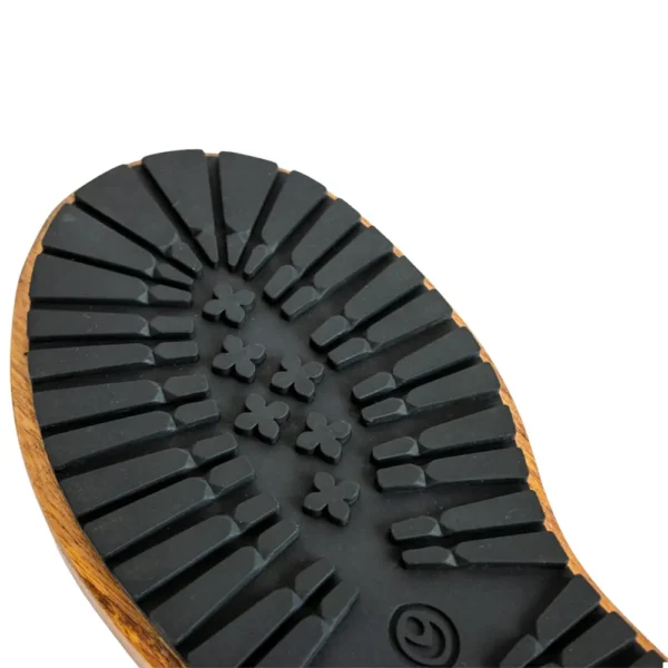 Close-up view of the black rubber sole on the Wooden Boot Imprint Paddle, showing a wood-edge, deep grooves, and clover-shaped treads in the centre.