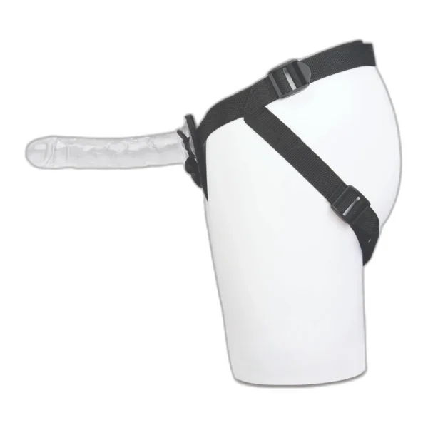 A transparent strap-on dildo attached to a black harness, shown on a white mannequin torso from the side.