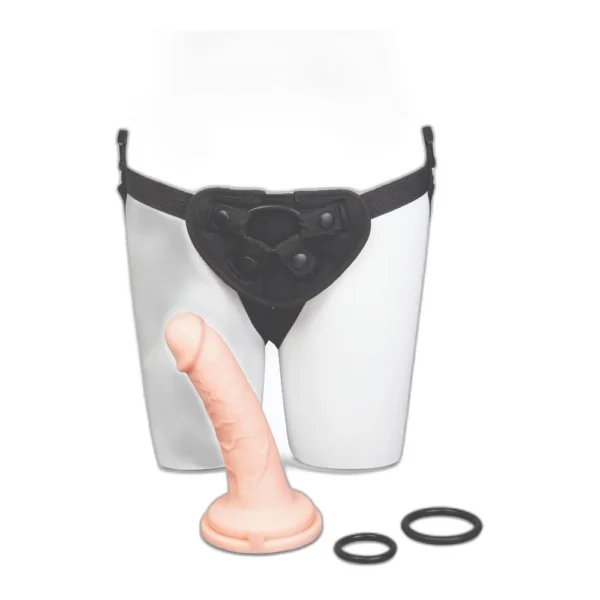 me-you-us-ultracock-harness-kit-detail-3 A strap-on harness is shown on a mannequin torso, accompanied by a realistic-looking flesh-coloured dildo and two black O-rings, all set against a white background.