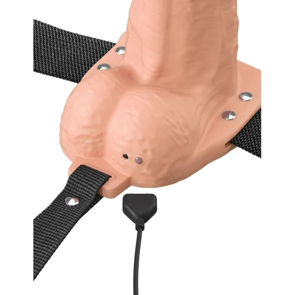 A close-up of a flesh-coloured strap-on sex toy with a harness and a plug-in power cord attached at the base.