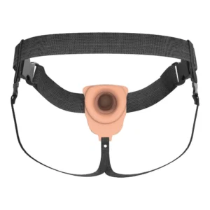 A wearable strap-on harness with a flesh-coloured silicone attachment at the centre, designed for securing and holding objects. The harness has adjustable black straps and plastic buckles for fastening.