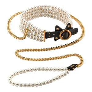 A pearl-studded collar with a gold chain lead, featuring a black leather strap and gold fittings. The handle of the lead is also adorned with pearls, matching the design of the collar.