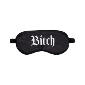 A black sleep mask with the word "Bitch" printed in white Gothic-style lettering across the front.