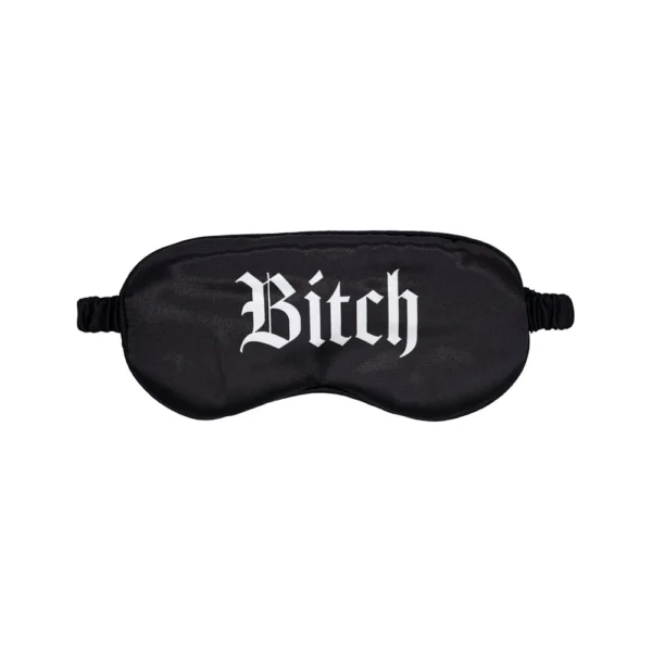 A black sleep mask with the word "Bitch" printed in white Gothic-style lettering across the front.