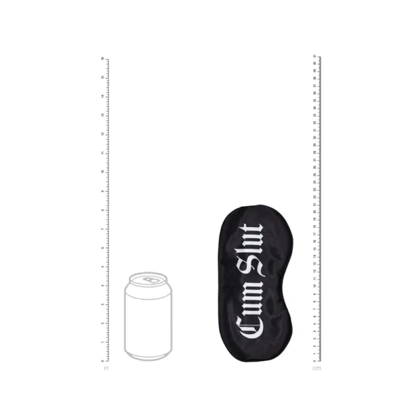 A black eye mask with "Cum Slut" written in white gothic lettering lies next to a drawing of a fizzy drink can for size comparison, with rulers on both sides showing inches and centimetres.