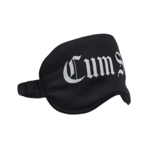 A black sleep mask with the word “Cum” in large white Gothic-style lettering across the front.