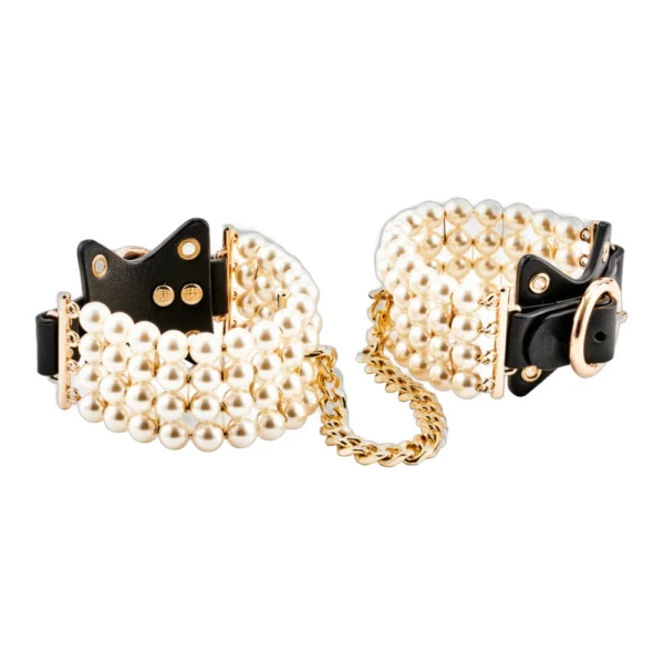 A pair of black leather wrist cuffs adorned with multiple rows of white pearls, connected by a short gold chain.
