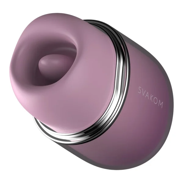 A close-up view of a purple SVAKOM branded sex toy with a smooth, oval shape and a silver metallic accent. The device has a rounded opening at one end, suggesting it is designed for external stimulation.
