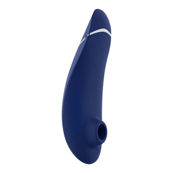 womanizer-premium2-blue-1 A navy blue, curved silicone device with a small circular opening at one end and a silver accent near the top, photographed on a white background.