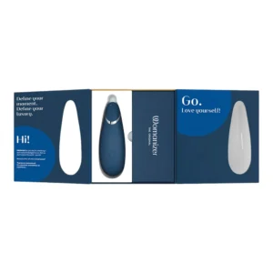 A blue Womanizer Go device in its open packaging, with encouraging messages printed inside, including “Go. Love yourself!” and “Define your moment. Define your luxury.”.