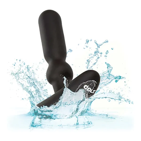 A black, waterproof personal massager with a rounded, segmented design splashes into clear blue water, emphasising its water-resistant feature.