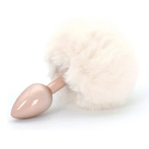 A pale pink butt plug with a large, fluffy, cream-coloured faux fur tail attached, displayed on a white background.